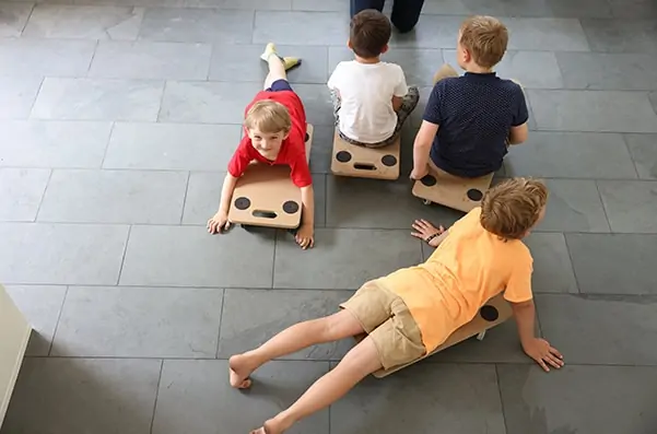 Kinder am Rollbrett in der Vorschule mit allen Sinnen